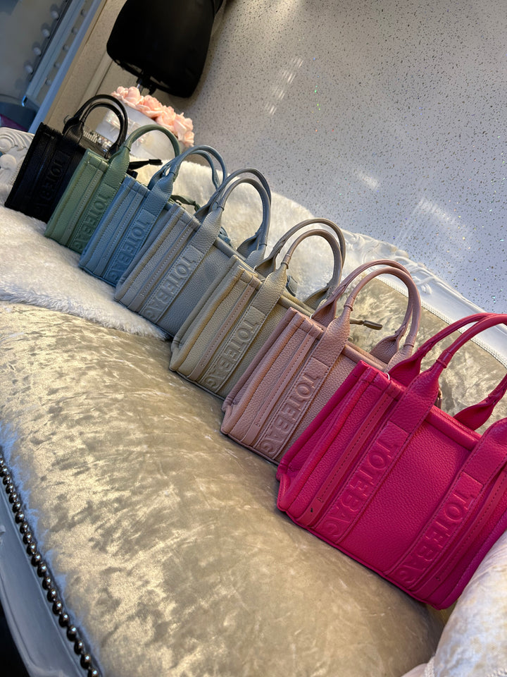 A collection of stripe dinky dot tote bags, with colours including green, blue, grey, and pink.