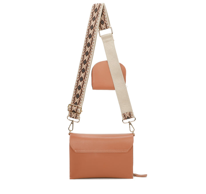 Brown leather crossbody bag with a patterned strap on a white background