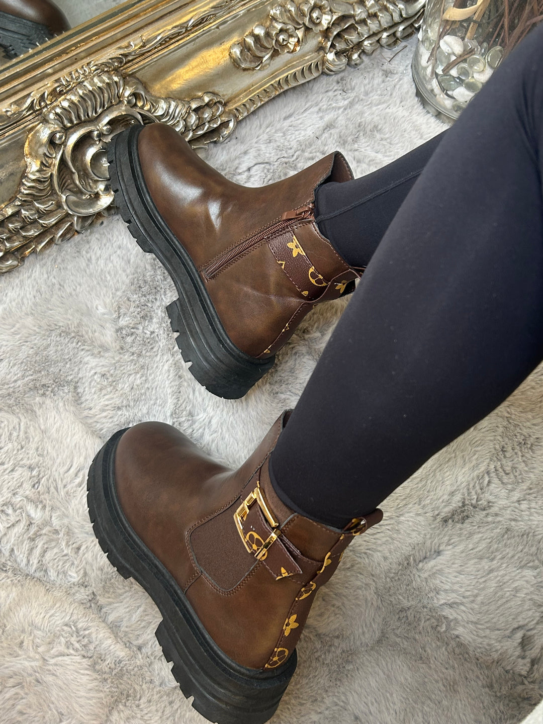 Chunky brown ankle boots with gold buckle detail, elastic side panels and thick black soles