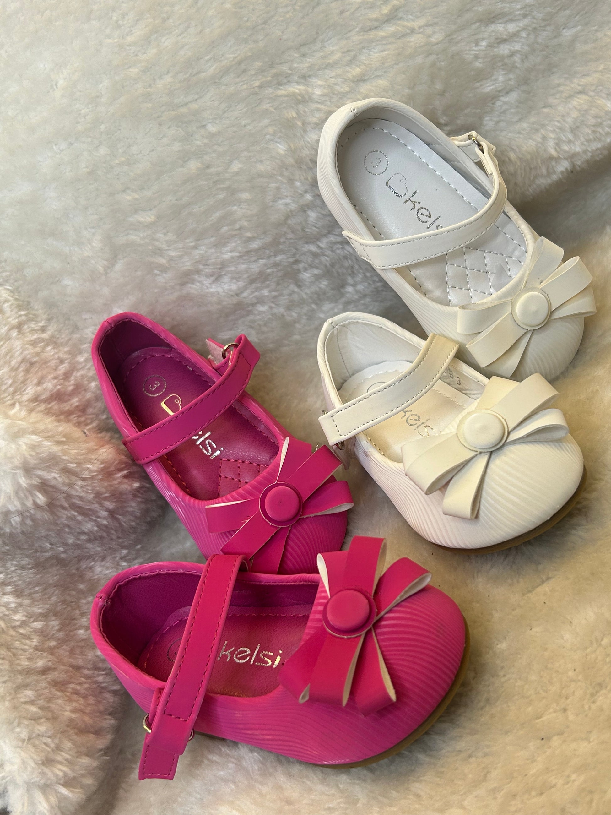 shoes in pink and white with quilted insole and large bow detail on the front