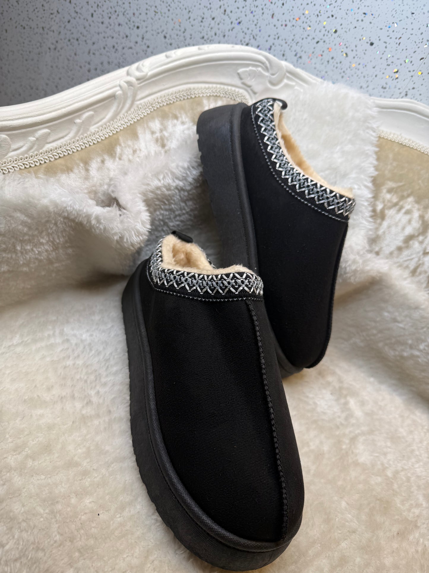 Black faux slippers with white fur lining
