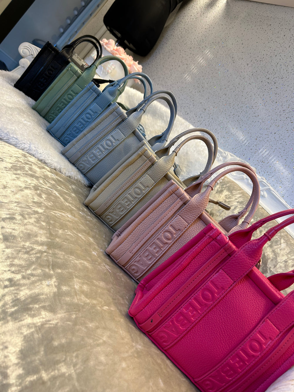 A collection of stripe dinky dot tote bags, with colours including green, blue, grey, and pink.