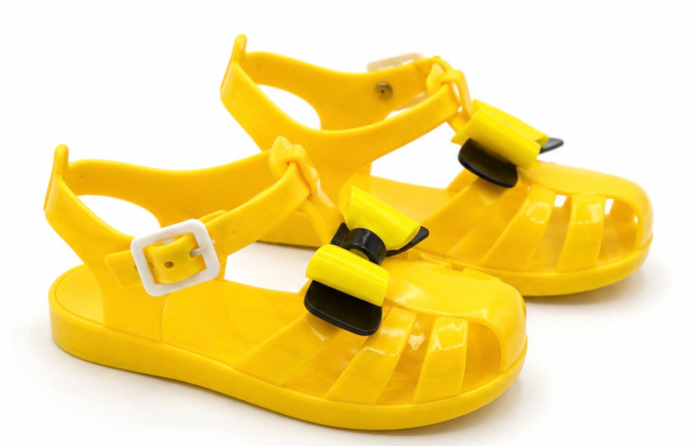 Girls colourful jelly sandals collection featuring yellow, black and glitter gold styles with decorative bows
