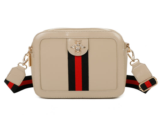 Beige handbag with a red and black striped strap on a beige background with a bee buckle design