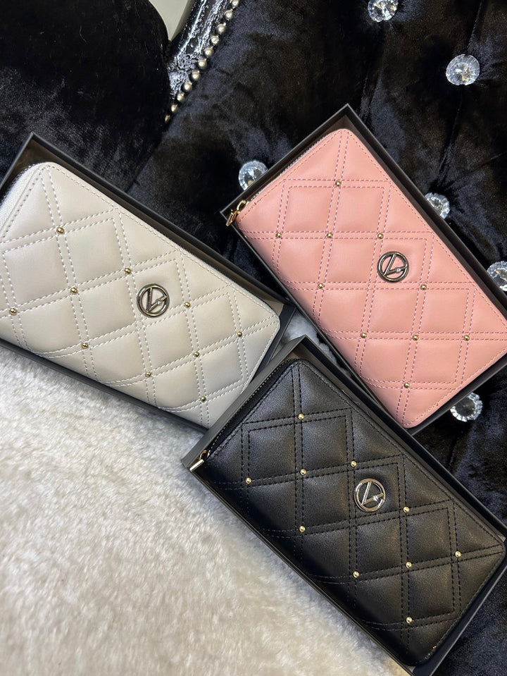Three quilted leather purses in pink, white, and black, displayed side by side with zip compartments visible.