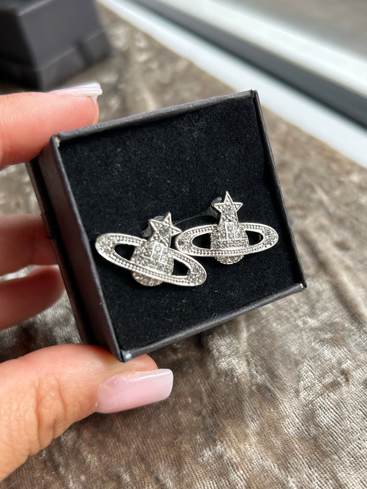 A pair of silver-colored star planet earrings 