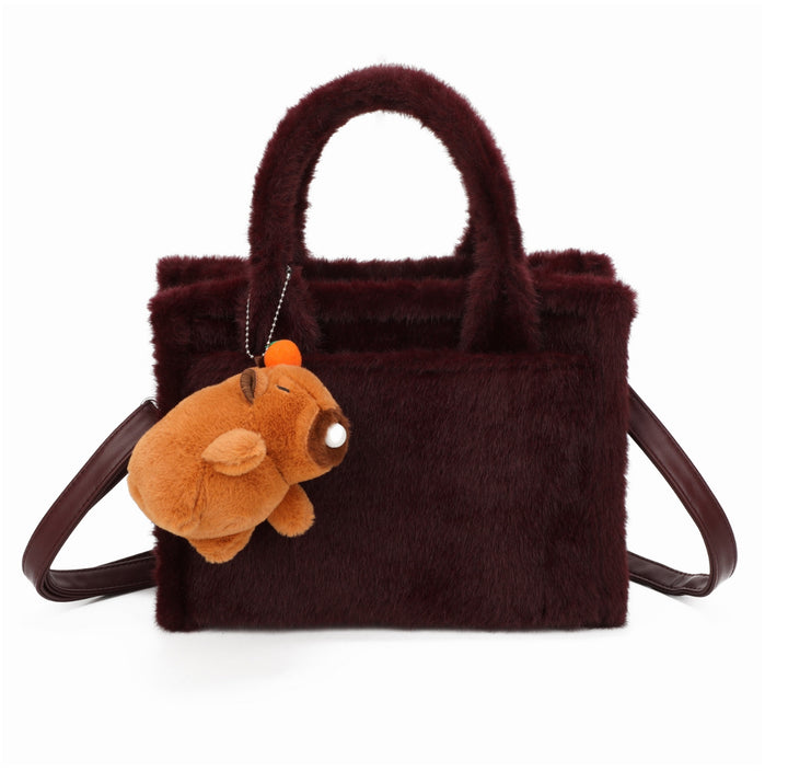 Wine faux-fur tote bag with a small brown teddy bear keychain and matching handles and strap.