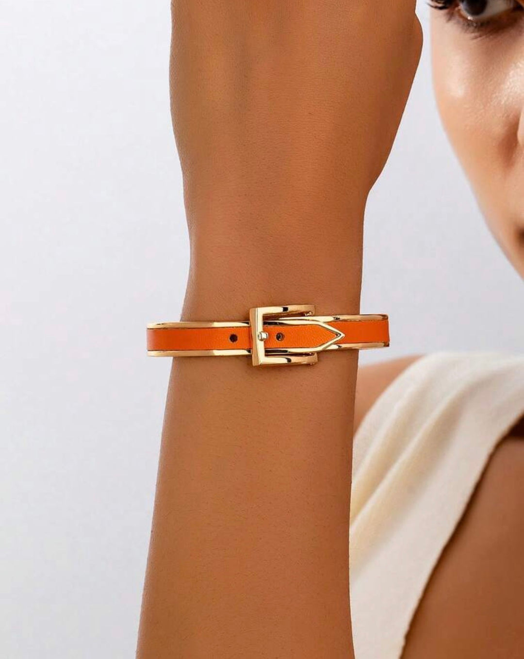     Polished gold buckle cuff bracelet with orange enamel detail
