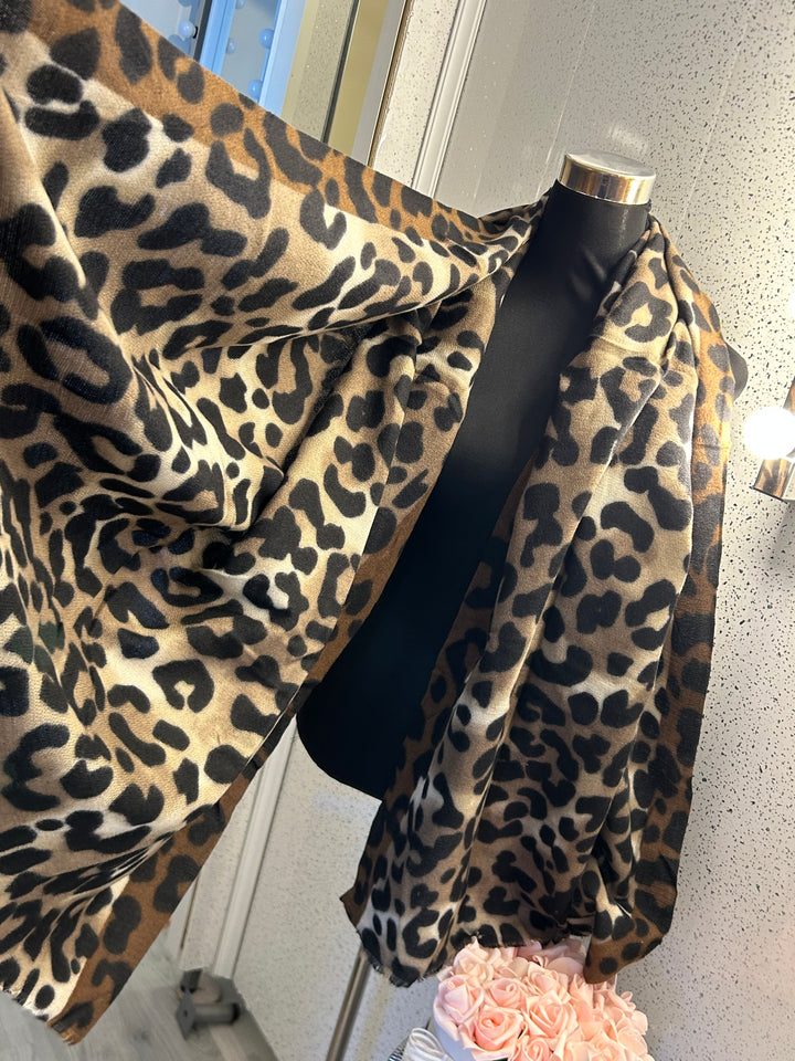 A leopard print scarf with frayed edges, in two different colour tone browns