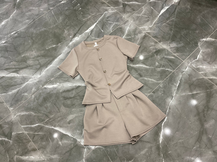 Beige co ord set flat lay gold button detail top and tailored shorts