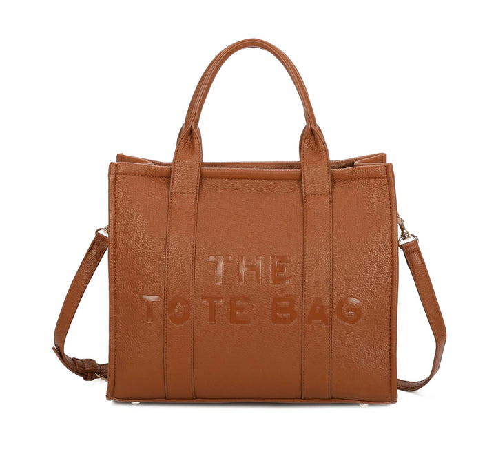 A brown tote bag with embossed ‘The Tote Bag’ text, structured design with top handles and detachable shoulder strap