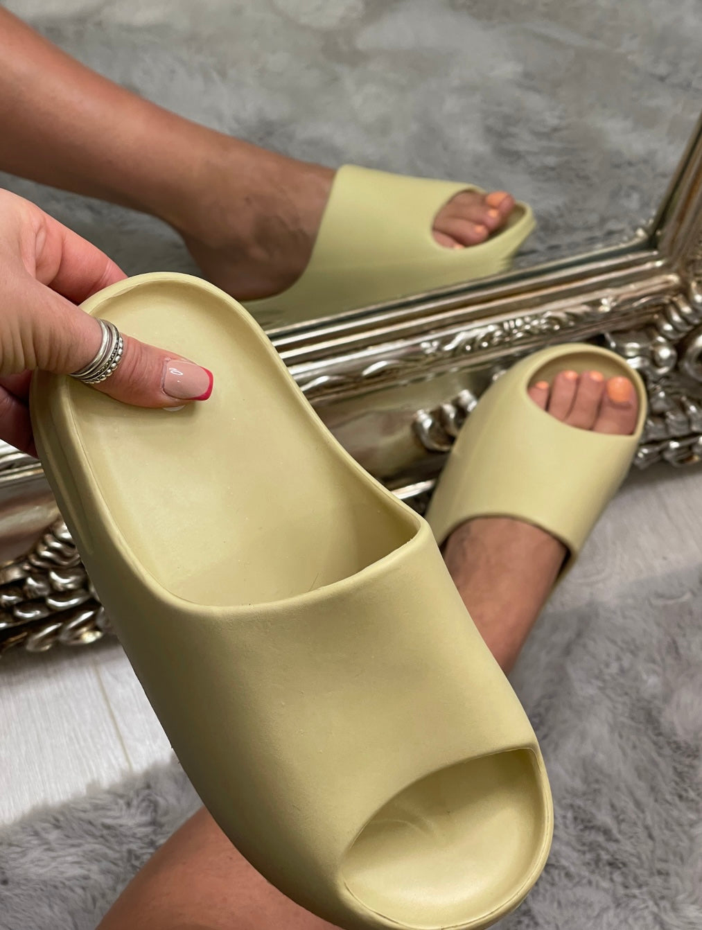 A pair of yellow/ beige plastic slip on sliders 