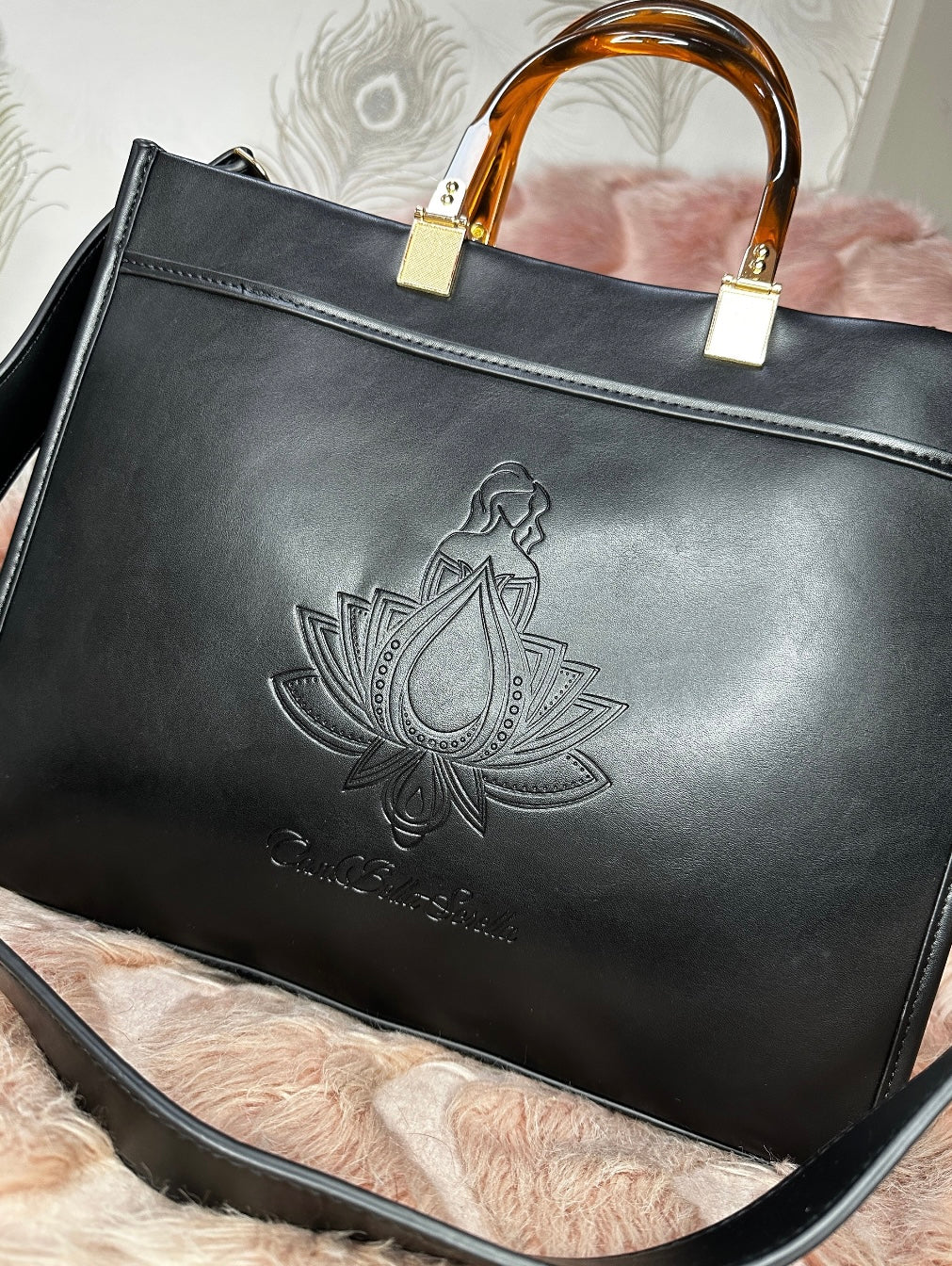 black faux leather tote bag with the cbs logo on the front