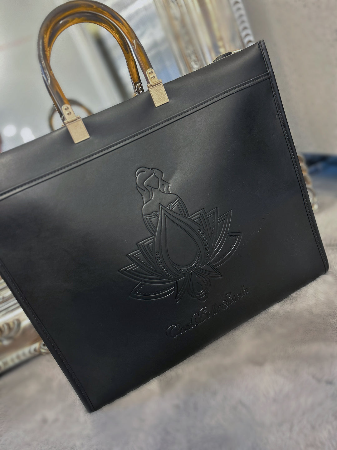 black faux leather tote bag with the cbs logo on the front