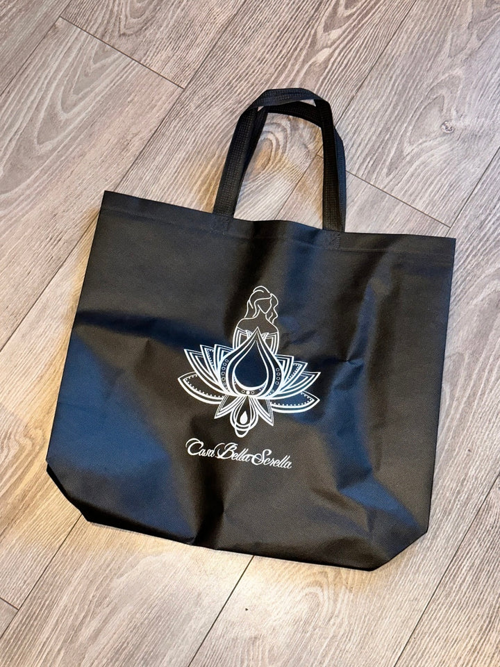 A black shopping bag with a white floral pattern and text that reads &