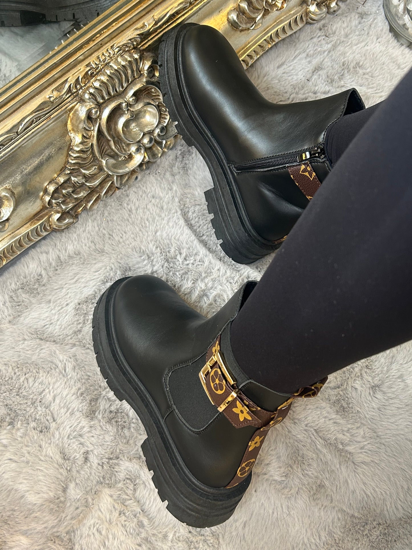 Chunky black ankle boots with gold buckle detail, elastic side panels and thick black soles. 