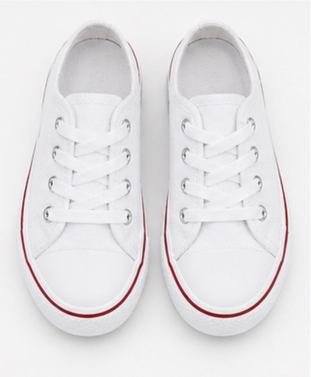 White kids canvas trainers with lace-up fastening and classic chunky sole design.