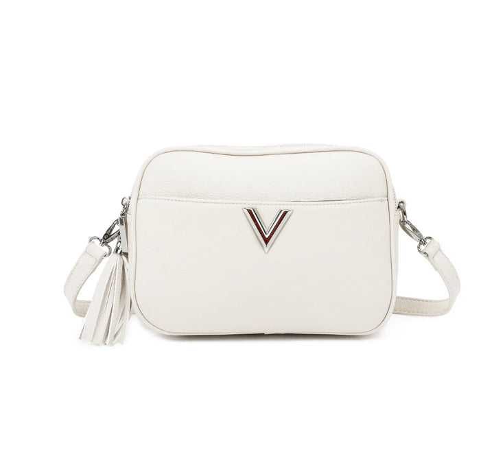 A white faux leather crossbody bag with a double zip closure, silver tone metal hardware, and an adjustable long strap. It features a front pocket,