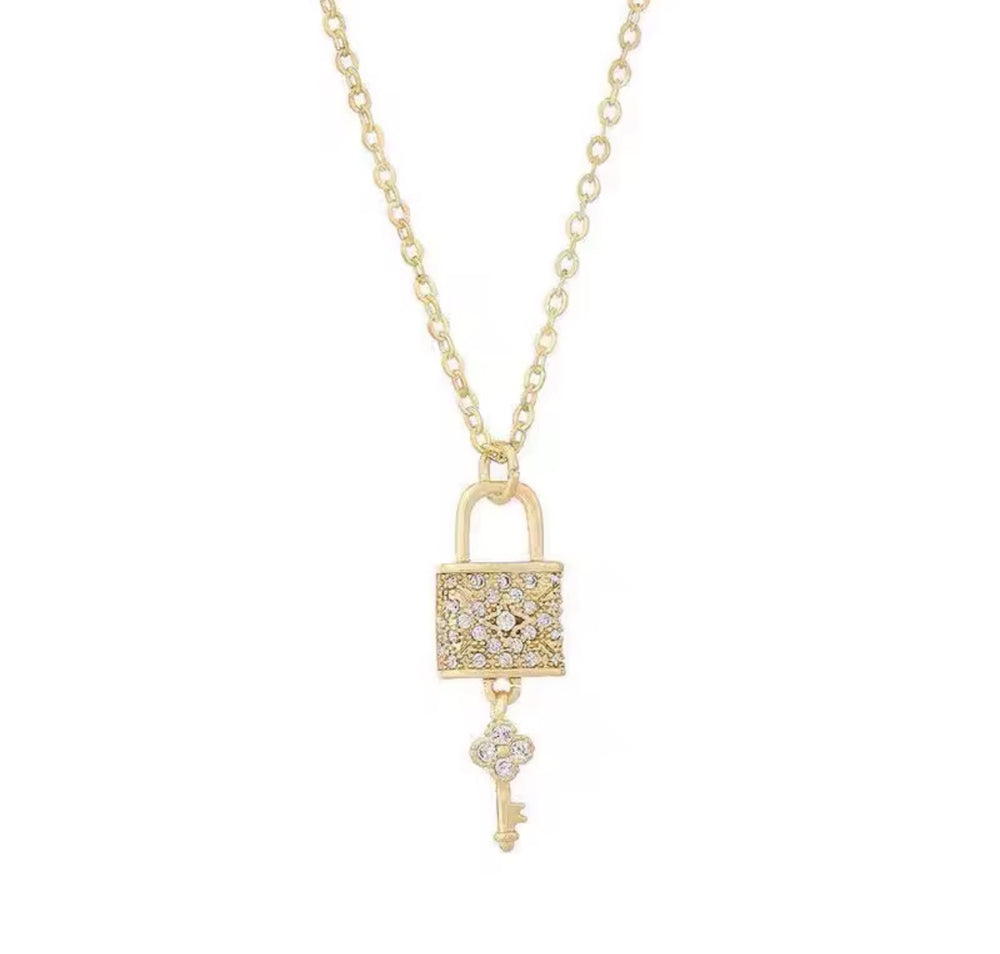 Gold lock and key pendant necklace with crystal detail on a fine gold chain