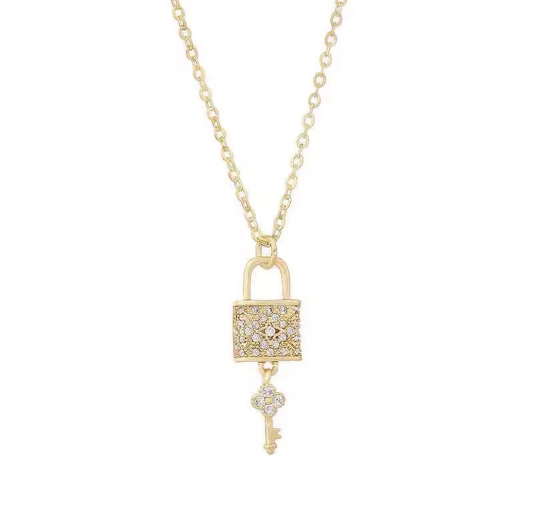 Gold lock and key pendant necklace with crystal detail on a fine gold chain
