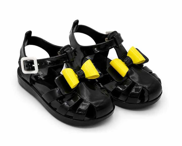 Girls colourful jelly sandals collection featuring yellow, black and glitter gold styles with decorative bows