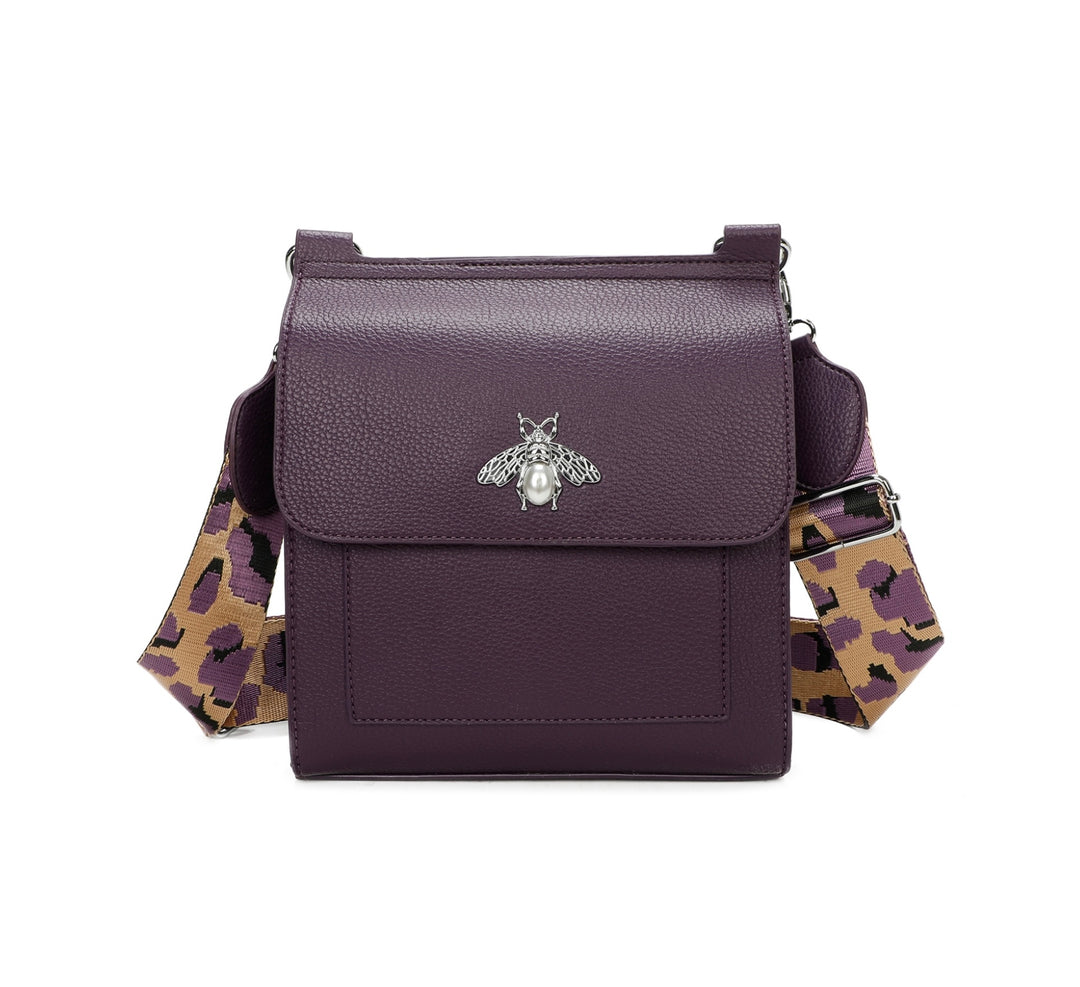 Purple crossbody bag with silver bee and pearl detail on flap, adjustable monochrome patterned straw
