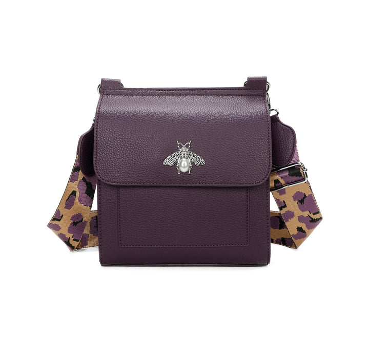 Purple crossbody bag with silver bee and pearl detail on flap, adjustable monochrome patterned straw