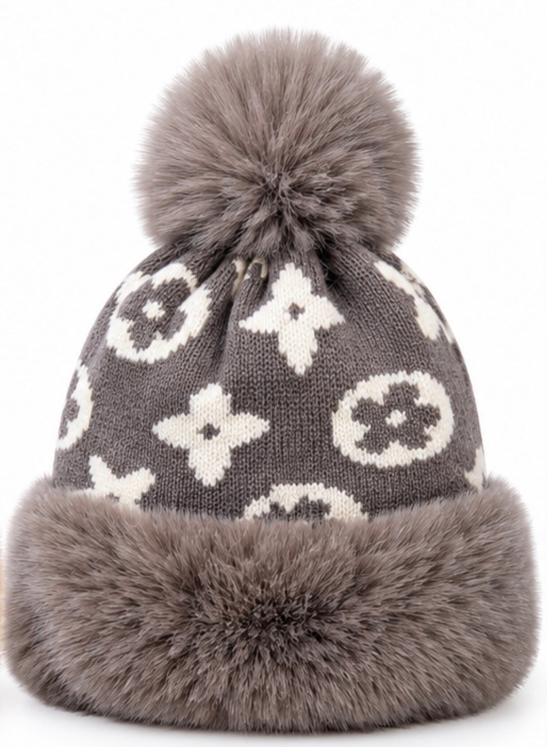 Luxury knitted winter bobble hats in camel beige and grey with cream monogram-style pattern, oversized fluffy pom poms, thick faux fur trims and soft fleece lining.