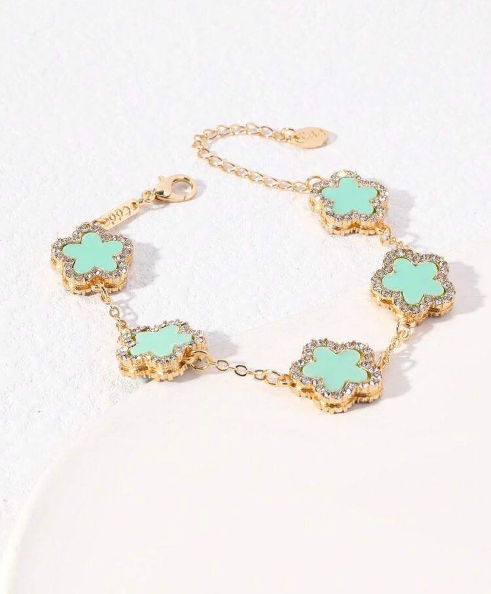     Adjustable gold bracelet with five mint clover charms and crystal detailing