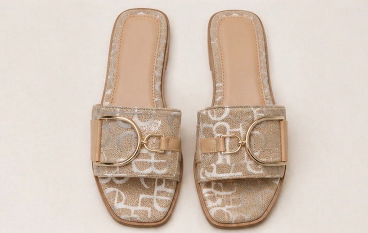 Rose gold monogram buckle sliders worn by model with slip on summer sandal design