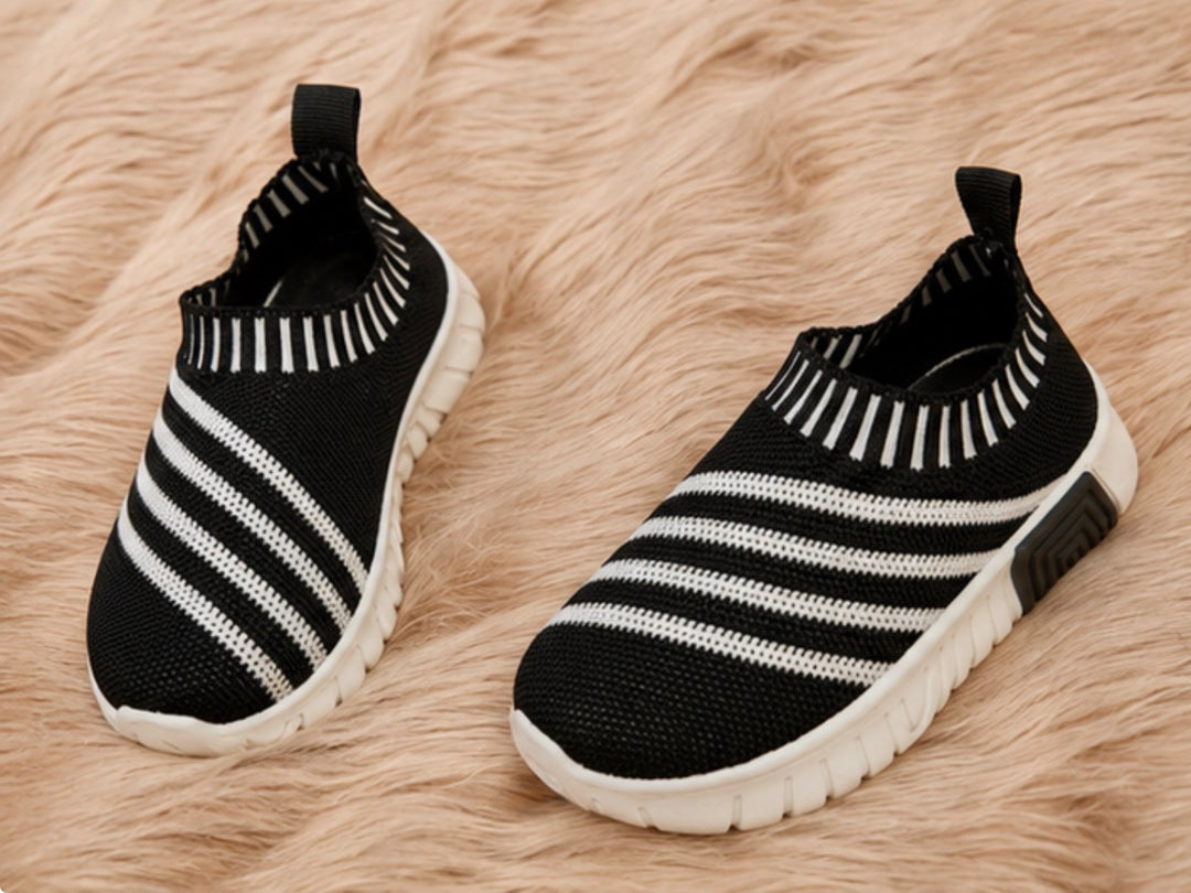 slip-on trainers in black and white design with lightweight flexible soles.