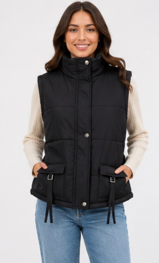 Black sleeveless padded gilet with high neck, front popper fastening, quilted design, adjustable buckle pocket details and cinched waist 