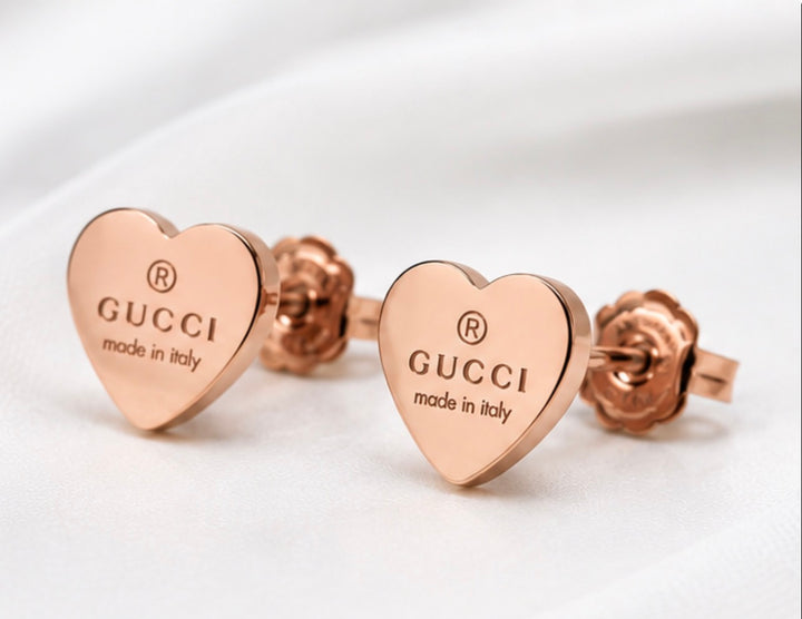 Rose gold heart stud earrings displayed in black jewellery gift boxes 