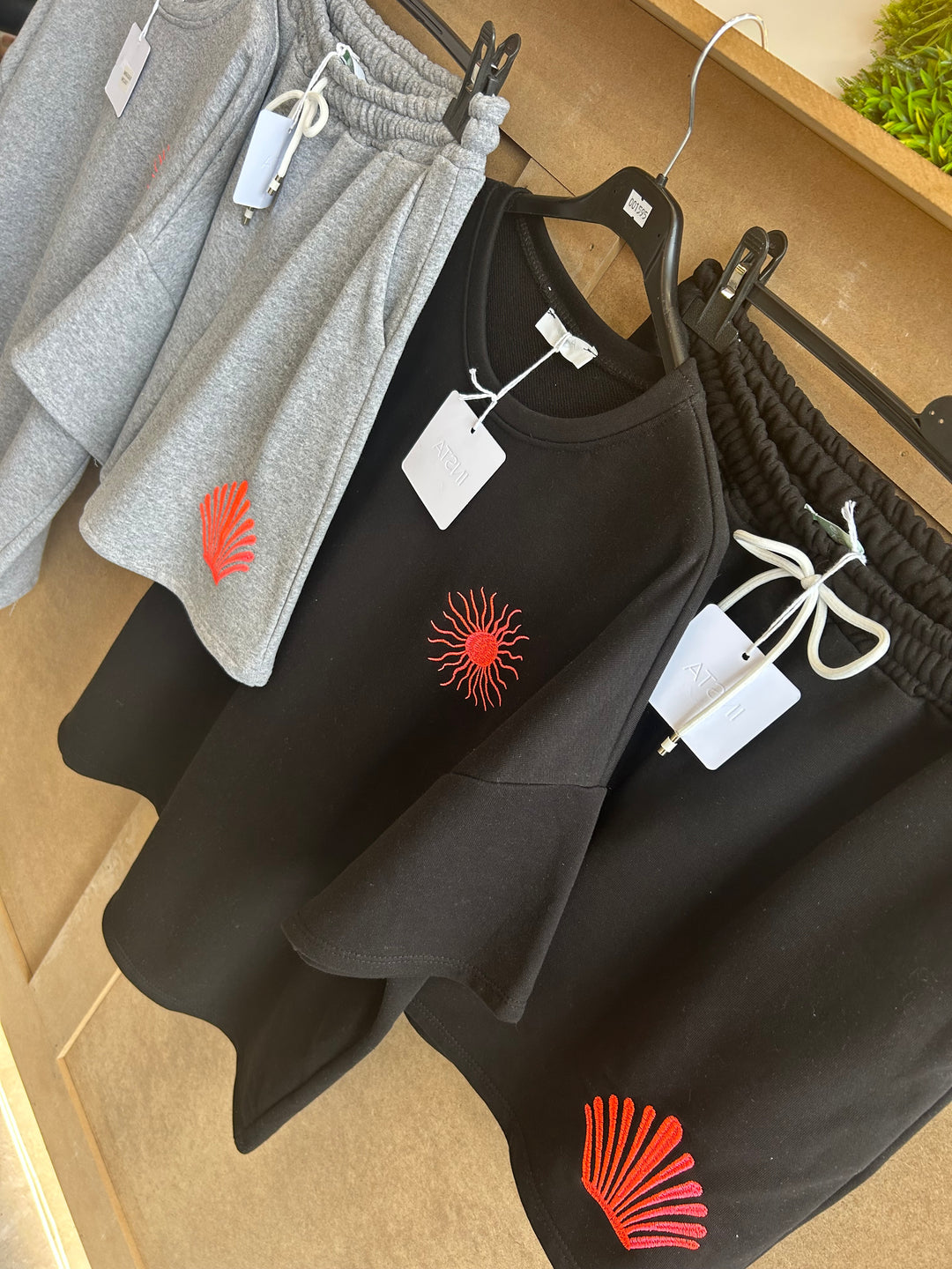 Black and gray clothing with red sun designs