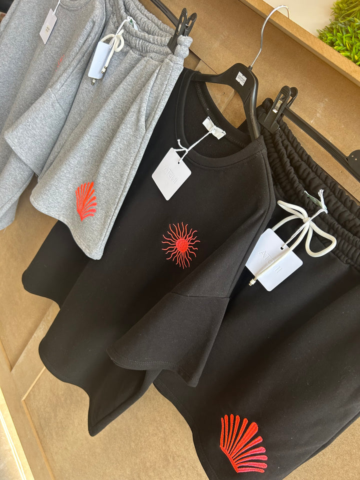 Black and gray clothing with red sun designs