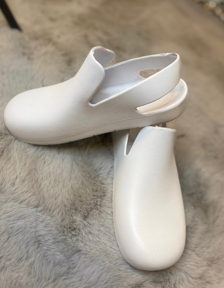 A pair of white slingback clogs 