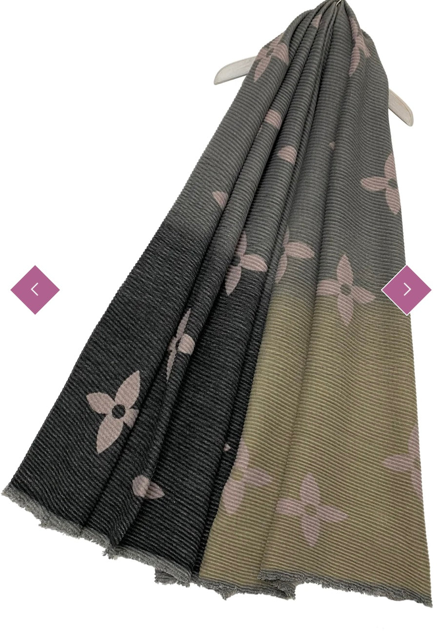A wool scarf with pleated texture and ombre design, featuring shades of grey and pink flower prints, 