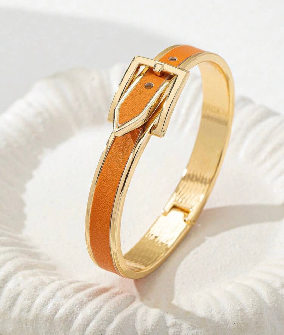     Polished gold buckle cuff bracelet with orange enamel detail