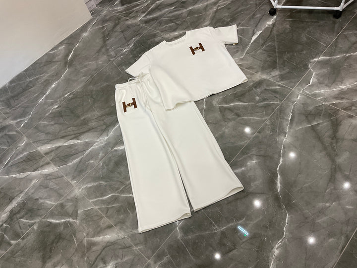 White outfit with brand logo on a gray marble floor