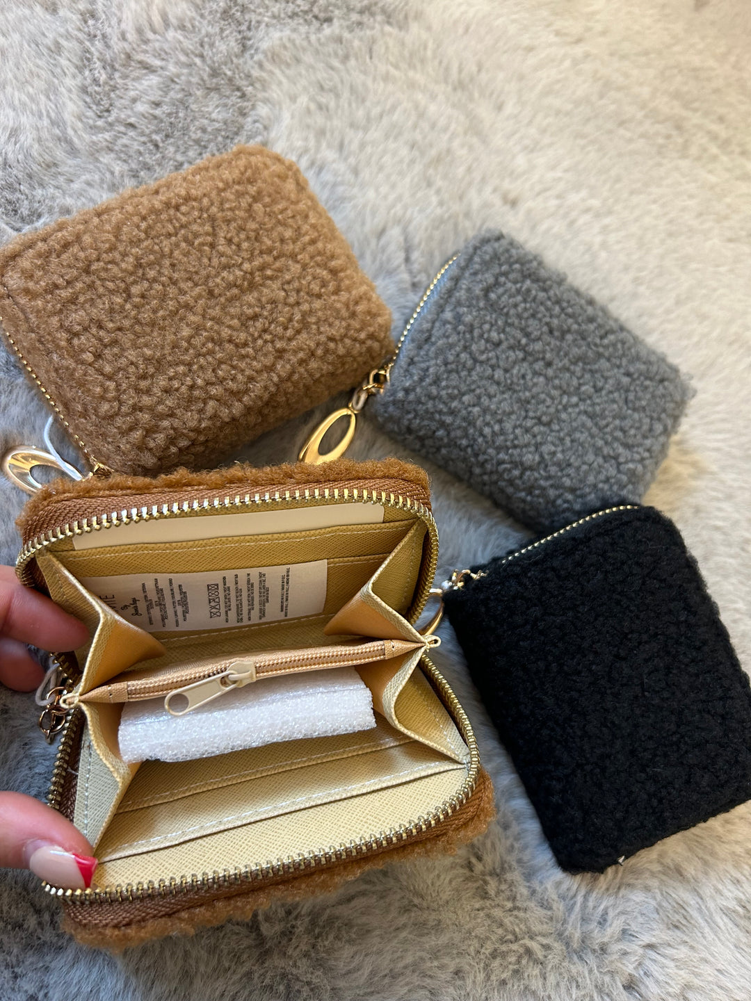 A fuzzy mini purses with gold zip detailing 