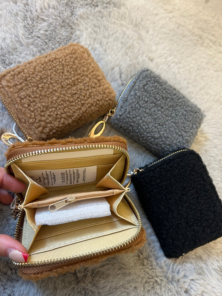 A fuzzy mini purses with gold zip detailing 