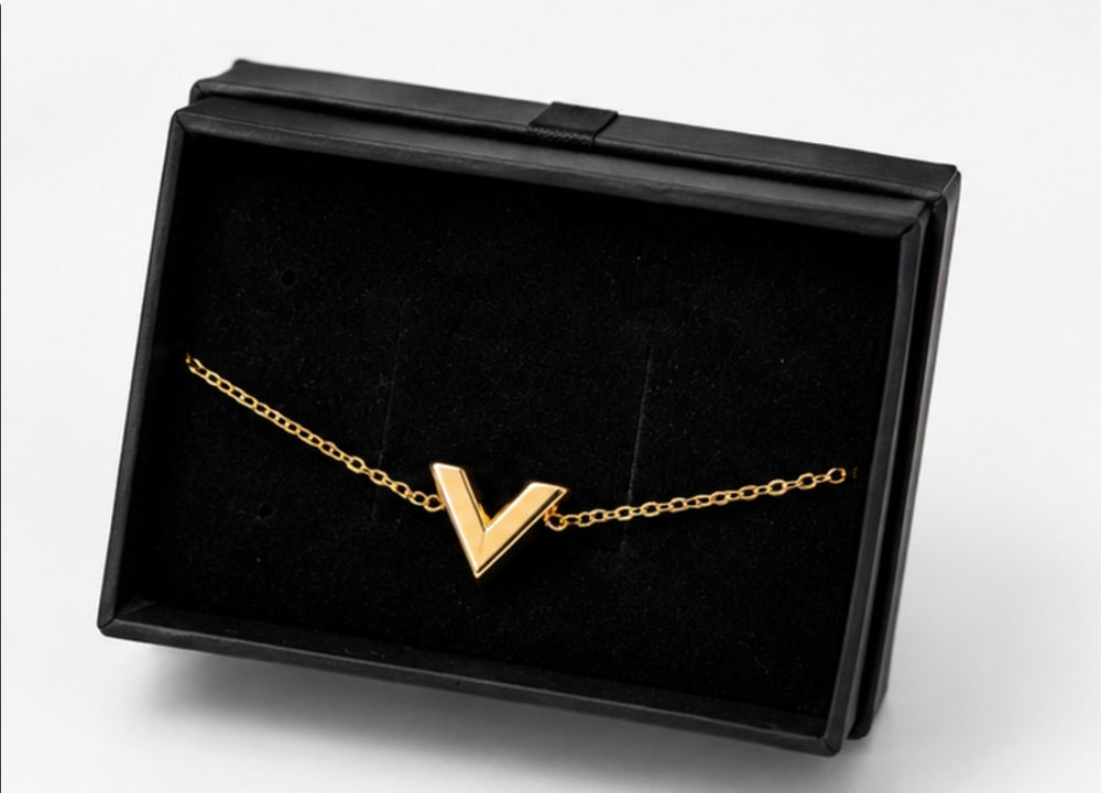 Gold V pendant necklace, featuring a minimalist stainless steel design on a delicate gold chain.