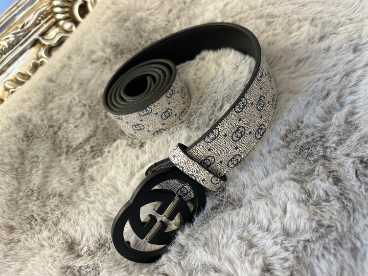 A coiled grey and black belt with a patterned buckle
