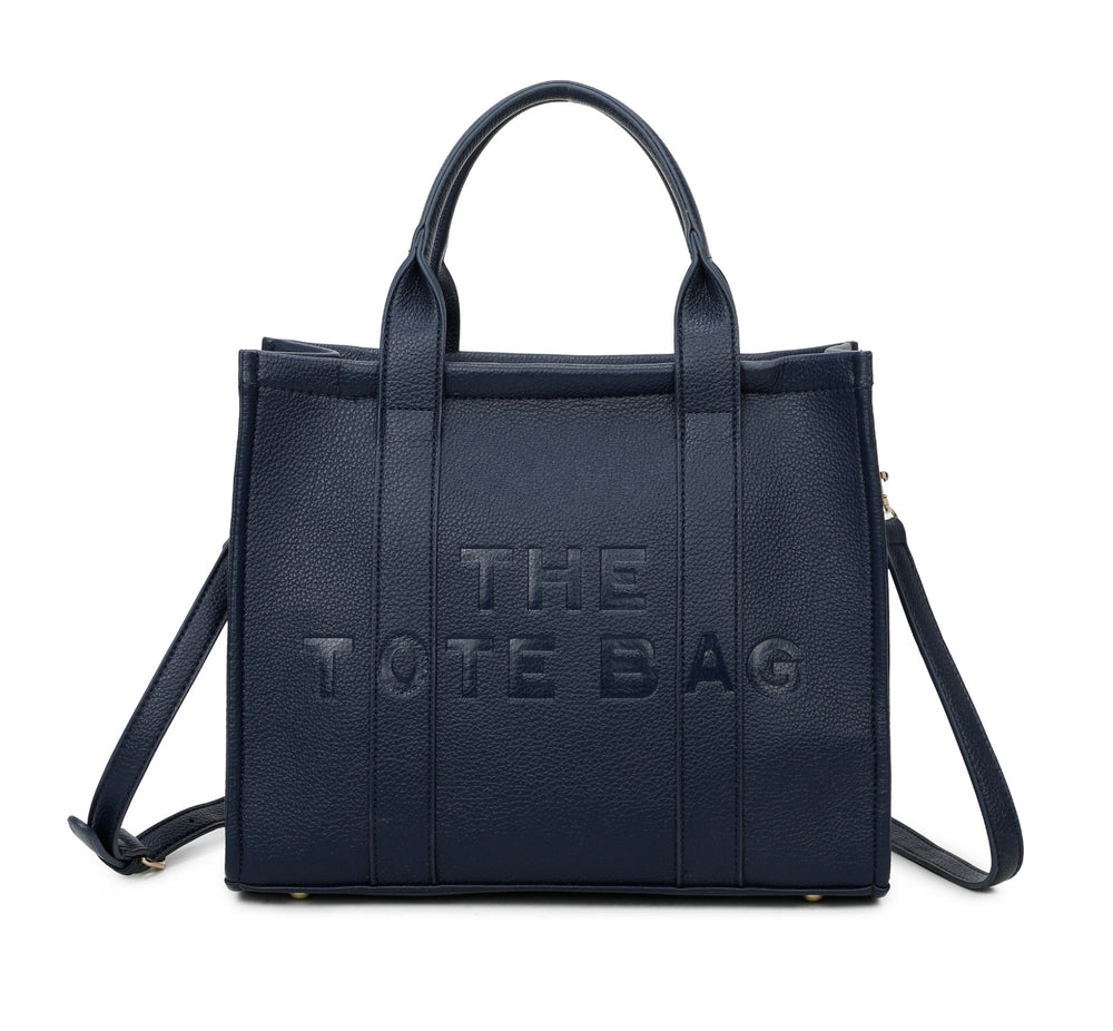 A navy tote bag with embossed ‘The Tote Bag’ text, structured design with top handles and detachable shoulder strap