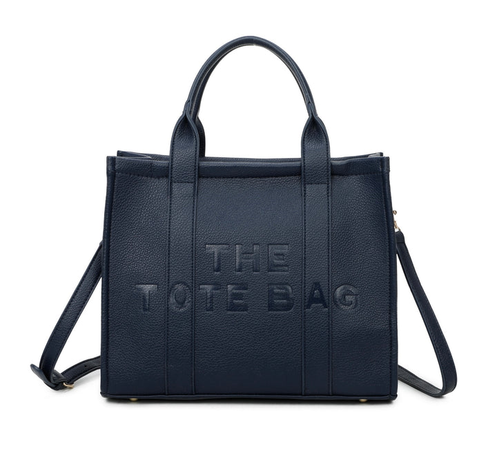 A navy tote bag with embossed ‘The Tote Bag’ text, structured design with top handles and detachable shoulder strap