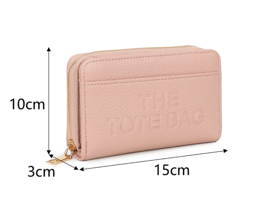 Pink wallet purse  with 'The Tote Bag' and a gold detail zip 
