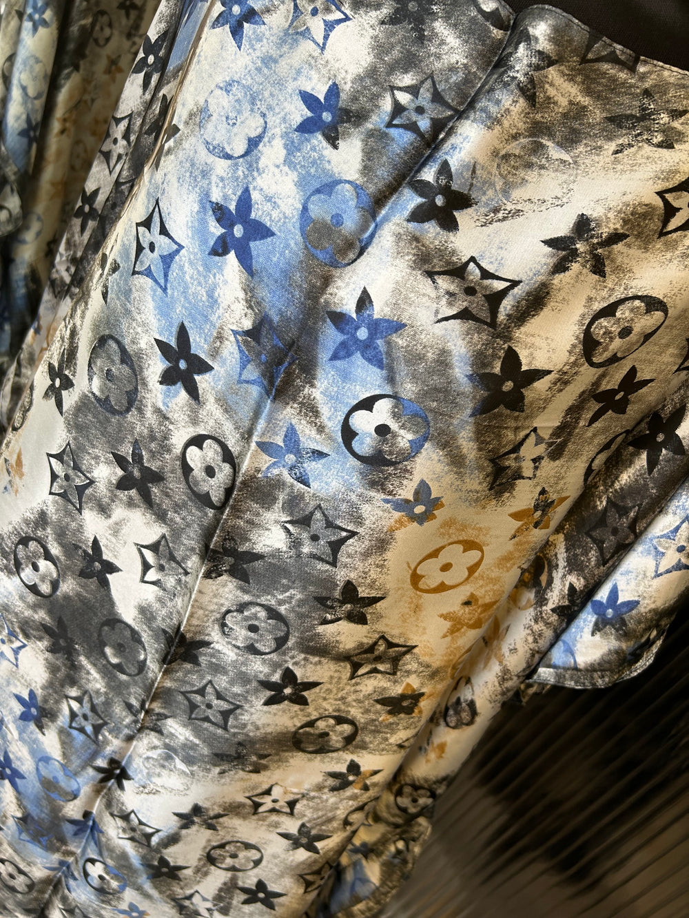 Close-up of a patterned fabric with stars, flowers, and abstract shapes.