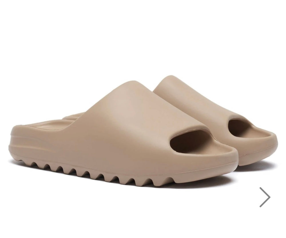 A pair of beige plastic slip on sliders 
