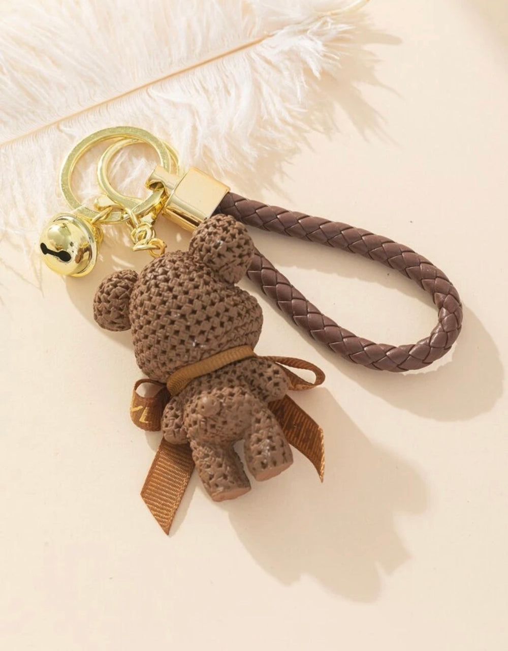     Brown teddy bear keyring with braided wrist strap and gold bell charm.