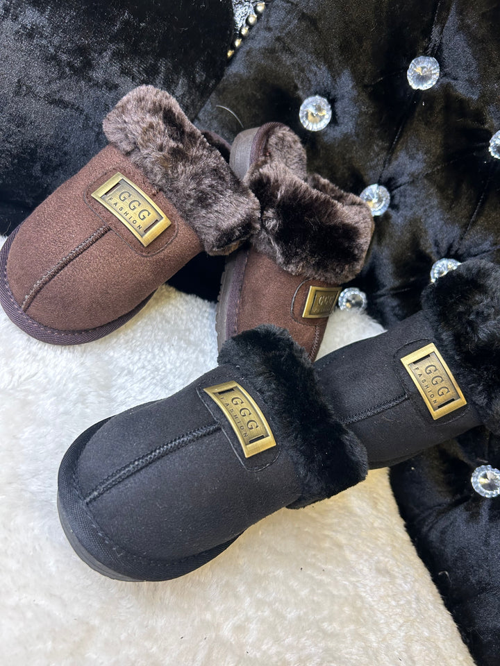 a choice of chocolate brown or black closed toe slip on faux fur slippers with gold buckle on the front